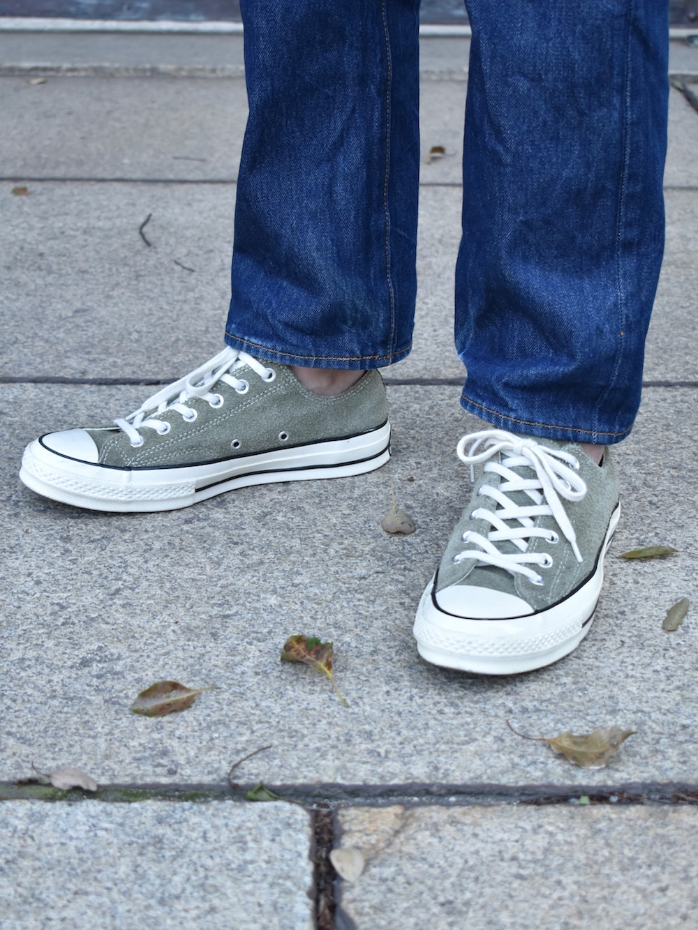 グレー系のブルゾン、ブルー系のデニムパンツ、グリーン系のスニーカーを着用したメンズの春コーディネートの3枚目の写真