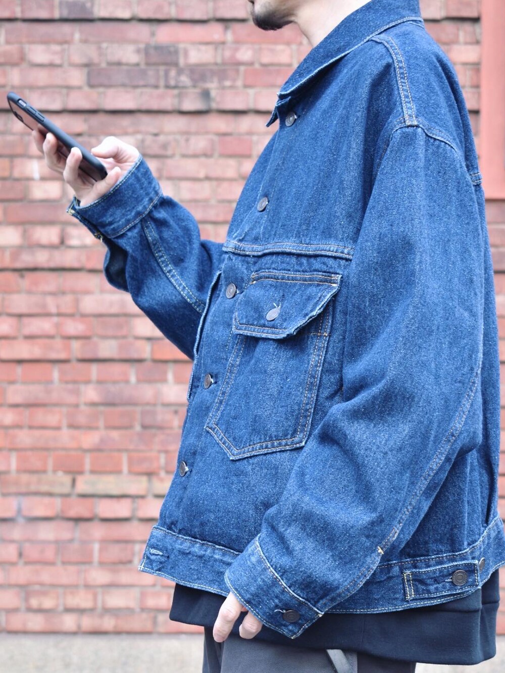 ブルー系のデニムジャケット、グレー系のチノパンツ、ベージュ系のサンダルを着用したメンズの冬コーディネートの3枚目の写真