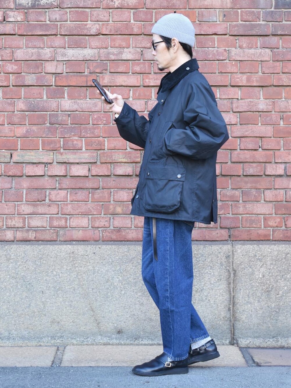 ブラック系のブルゾン、ブルー系のデニムパンツ、ブラック系のシューズを着用したメンズの秋コーディネートの2枚目の写真