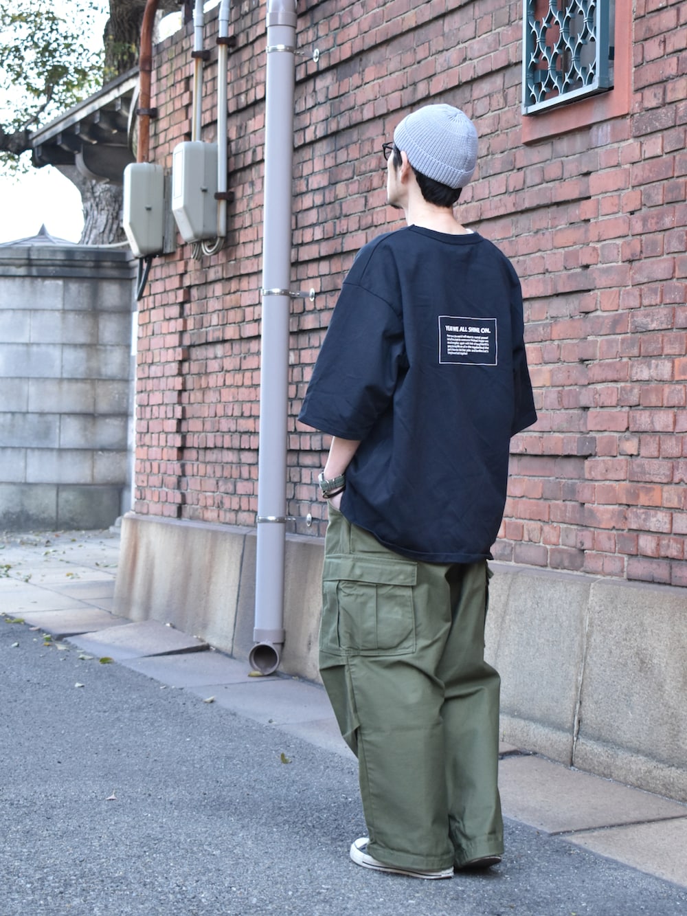 ブラック系のTシャツ/カットソー、グリーン系のカーゴパンツ、ブラック系のスニーカーを着用したメンズの春コーディネートの4枚目の写真