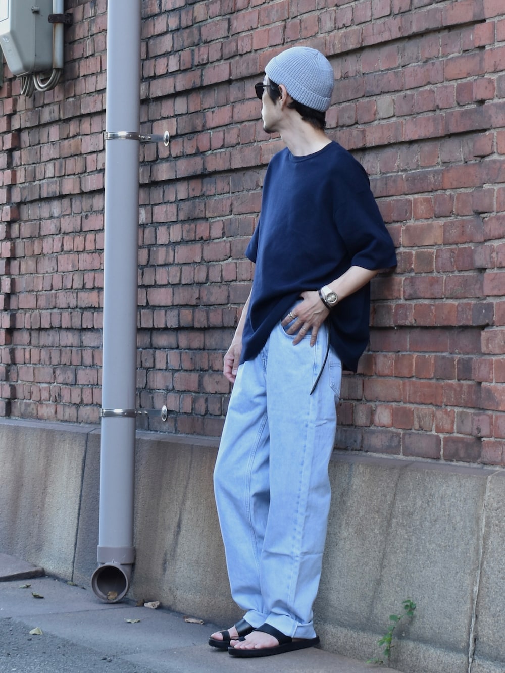 ブルー系のTシャツ/カットソー、ブルー系のデニムパンツ、ブラック系のサンダルを着用したメンズの夏コーディネートの2枚目の写真