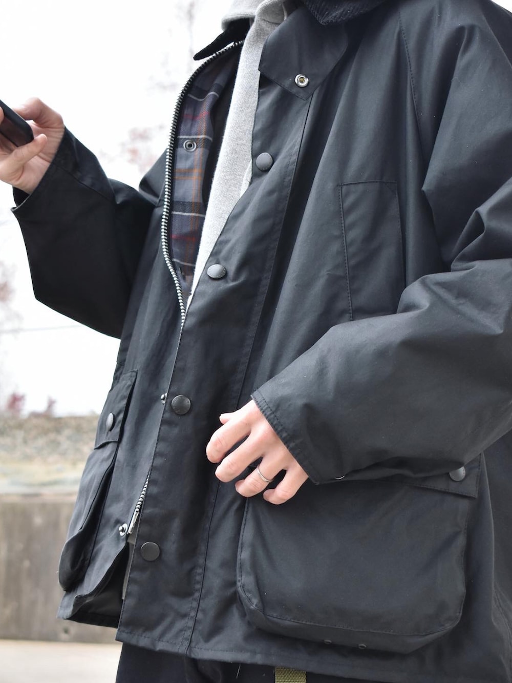 ブラック系のブルゾン、グレー系のパーカー、グレー系のチノパンツを着用したメンズの冬コーディネートの2枚目の写真