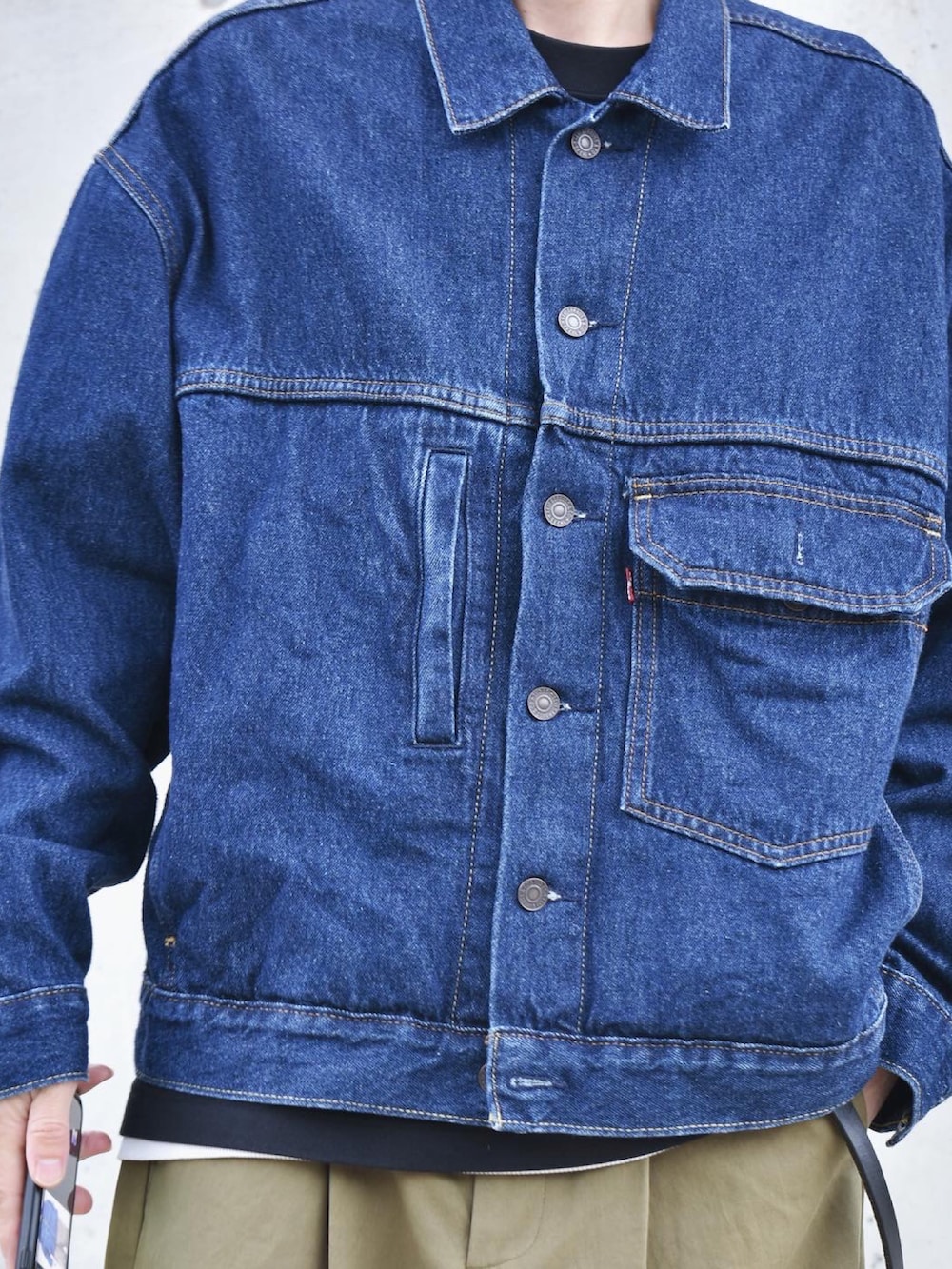 ブルー系のデニムジャケット、グリーン系のチノパンツ、ブラック系のローファーを着用したメンズの秋コーディネートの2枚目の写真