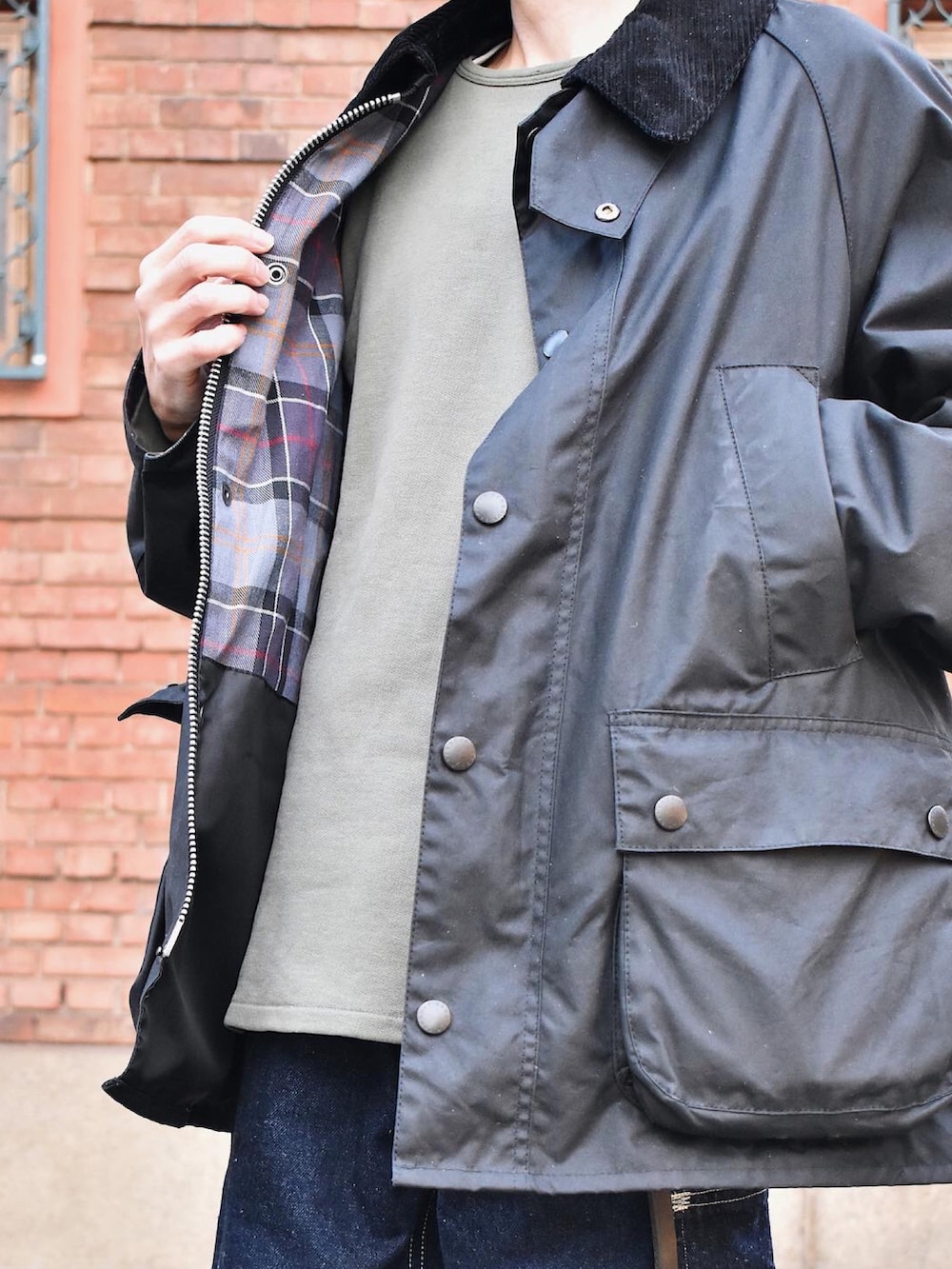 ブラック系のブルゾン、グリーン系のスウェット、ブルー系のデニムパンツを着用したメンズの冬コーディネートの2枚目の写真