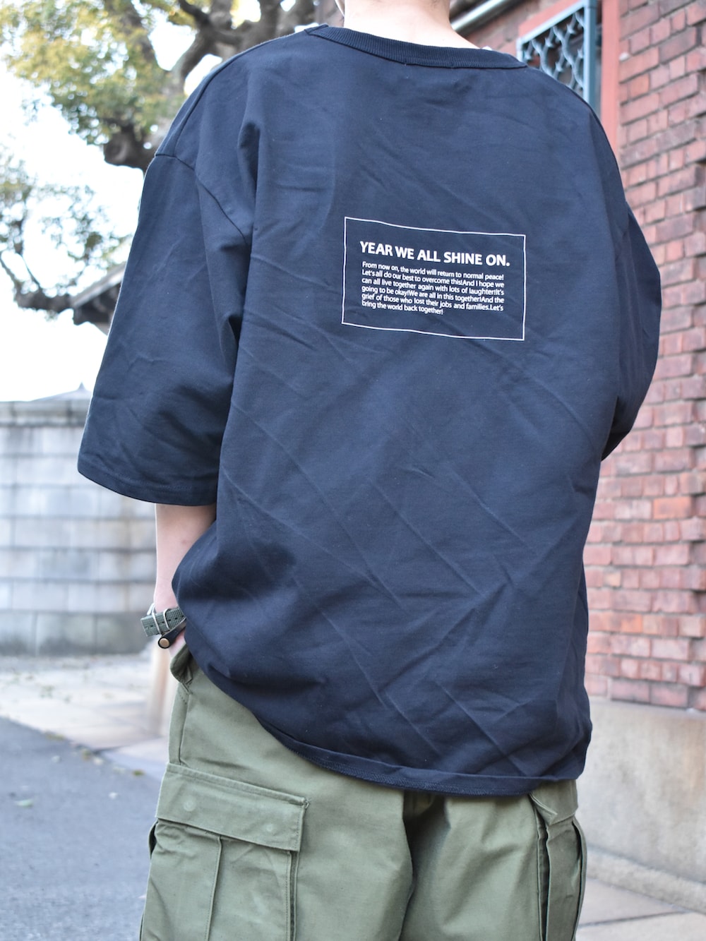 ブラック系のTシャツ/カットソー、グリーン系のカーゴパンツ、ブラック系のスニーカーを着用したメンズの春コーディネートの3枚目の写真