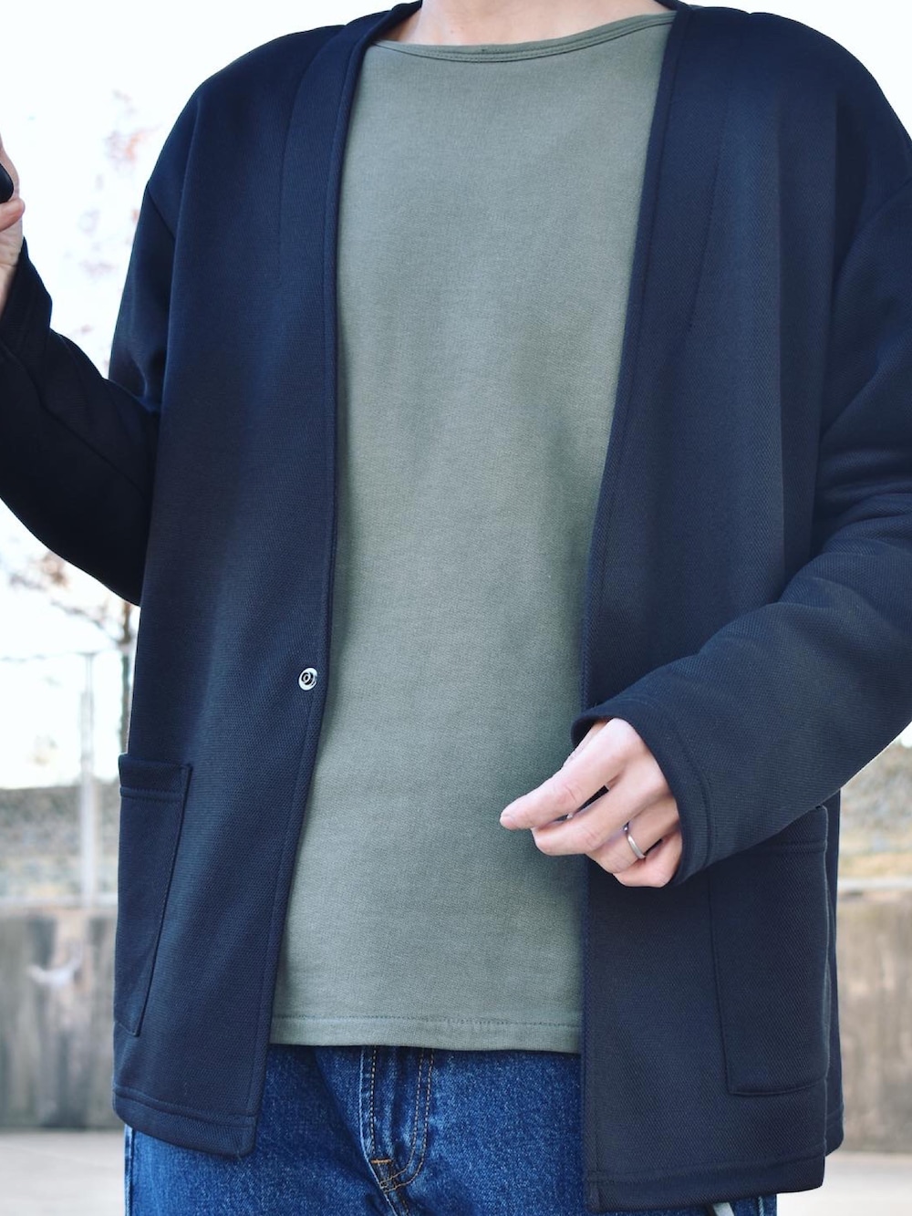 ブラック系のカーディガン/ボレロ、グリーン系のスウェット、ブルー系のデニムパンツを着用したメンズの冬コーディネートの2枚目の写真