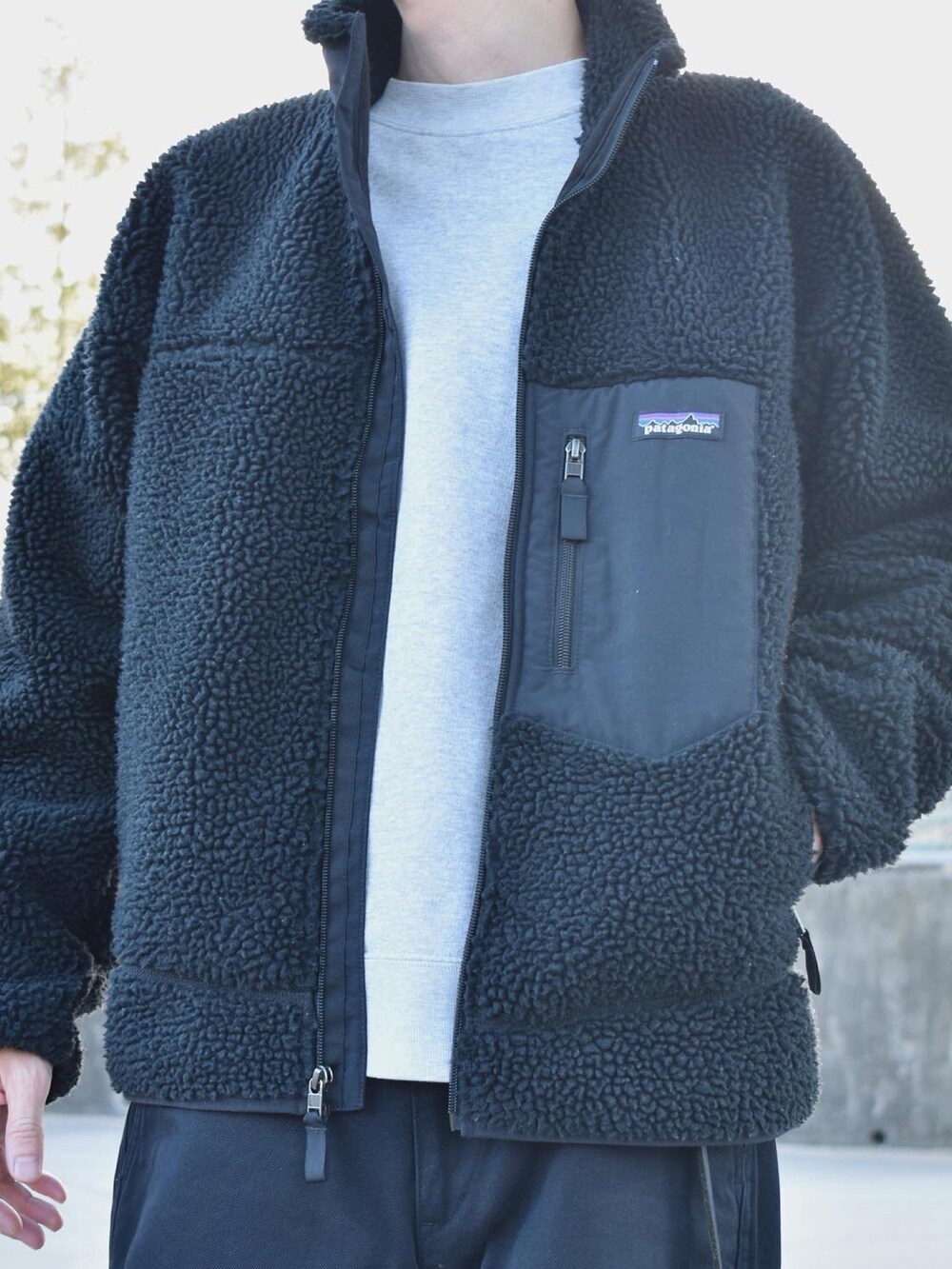 ブラック系のブルゾン、グレー系のスウェット、グレー系のチノパンツを着用したメンズの秋コーディネートの2枚目の写真