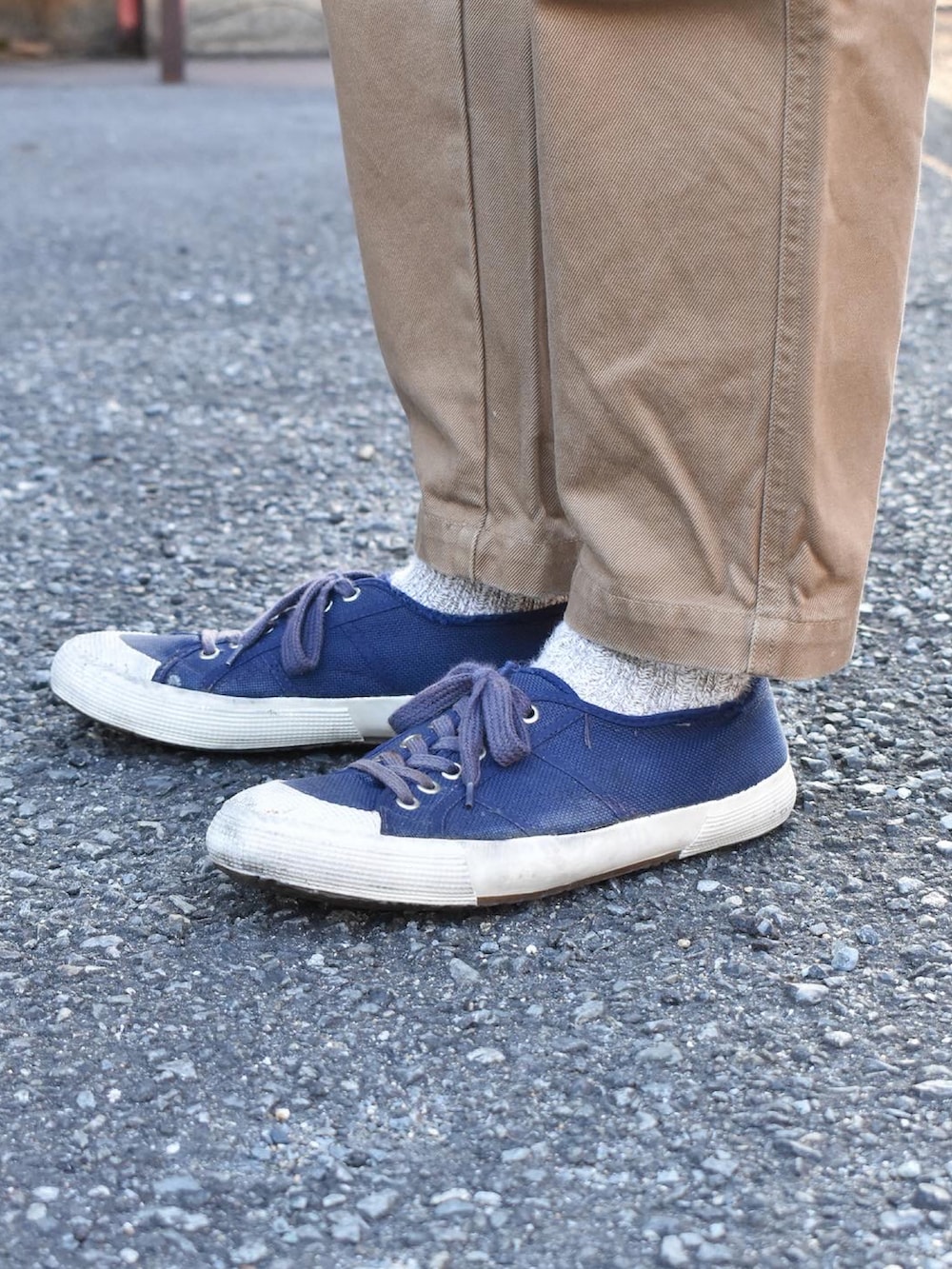 ブルー系のデニムジャケット、グレー系のパーカー、ブラウン系のチノパンツを着用したメンズの冬コーディネートの2枚目の写真