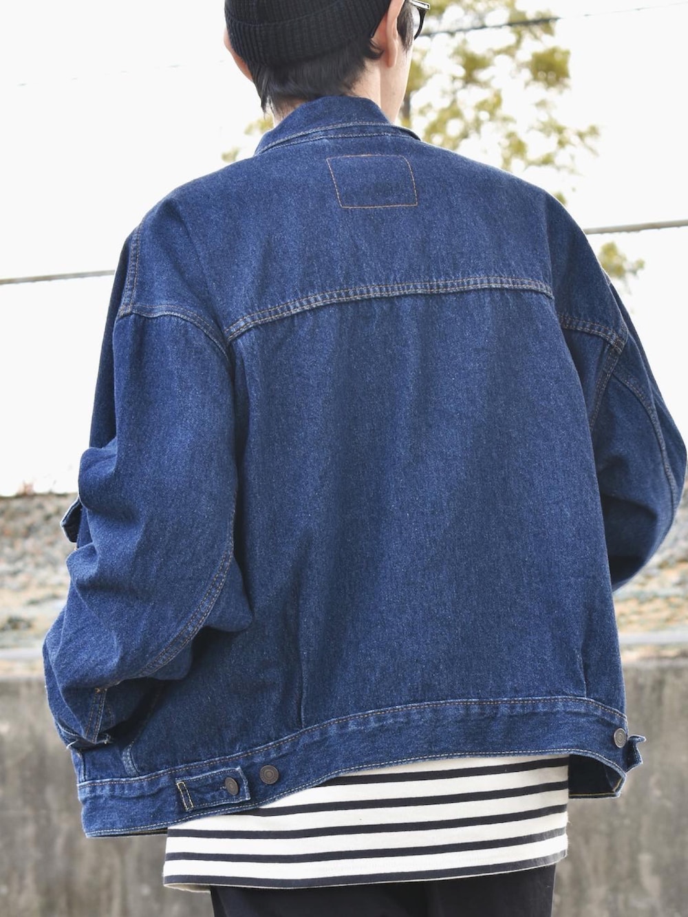 ブルー系のデニムジャケット、ブラック系のTシャツ/カットソー、グレー系のチノパンツを着用したメンズの秋コーディネートの3枚目の写真
