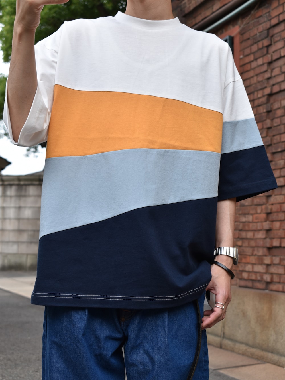 ホワイト系のTシャツ/カットソー、ブルー系のデニムパンツ、ブラック系のサンダルを着用したメンズの夏コーディネートの2枚目の写真