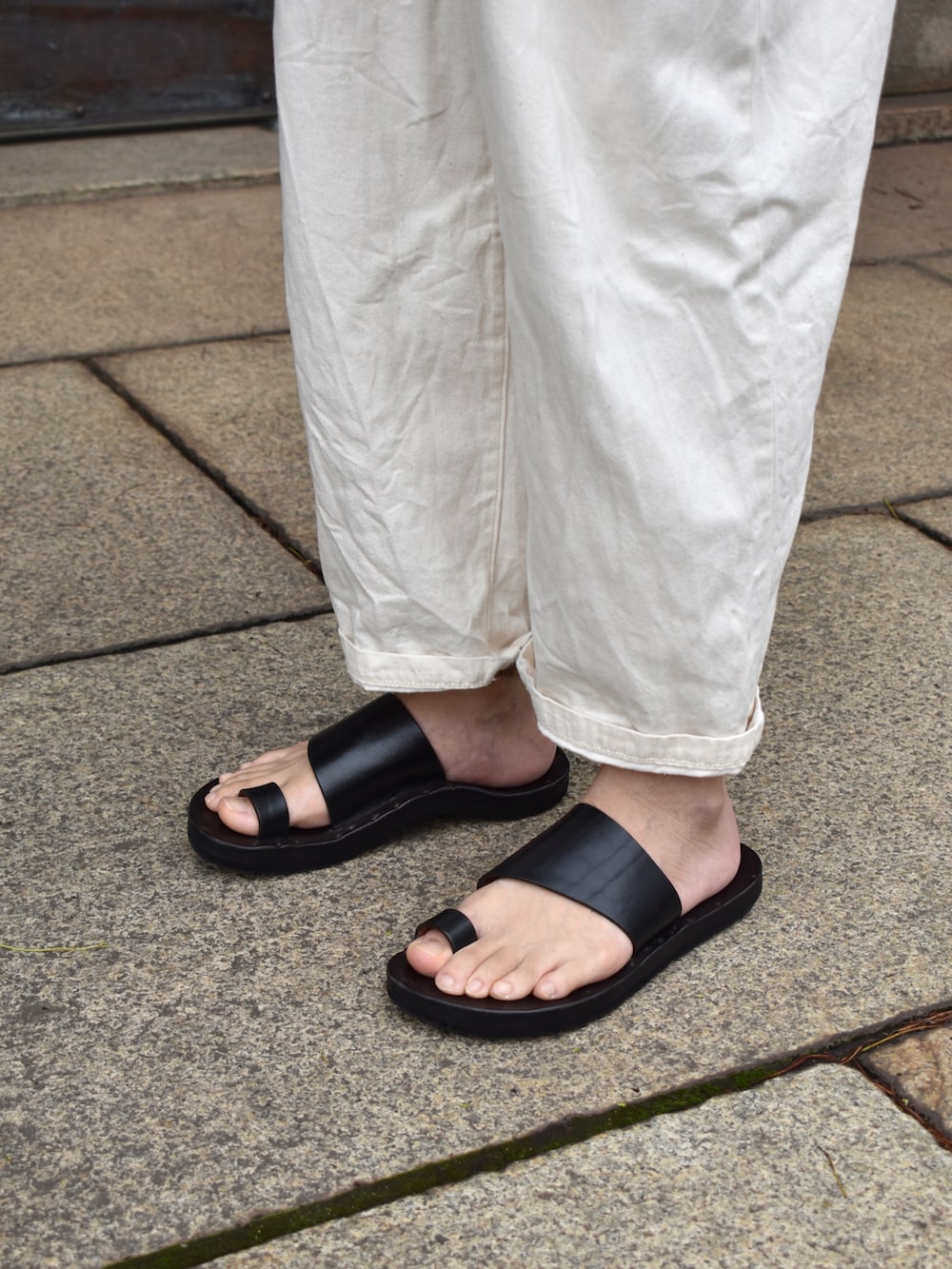 ベージュ系のTシャツ/カットソー、ホワイト系のパンツ、ブラック系のサンダルを着用したメンズの夏コーディネートの3枚目の写真