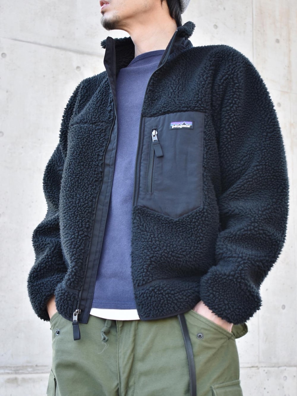 ブラック系のブルゾン、ブルー系のTシャツ/カットソー、グリーン系のカーゴパンツを着用したメンズの冬コーディネートの2枚目の写真