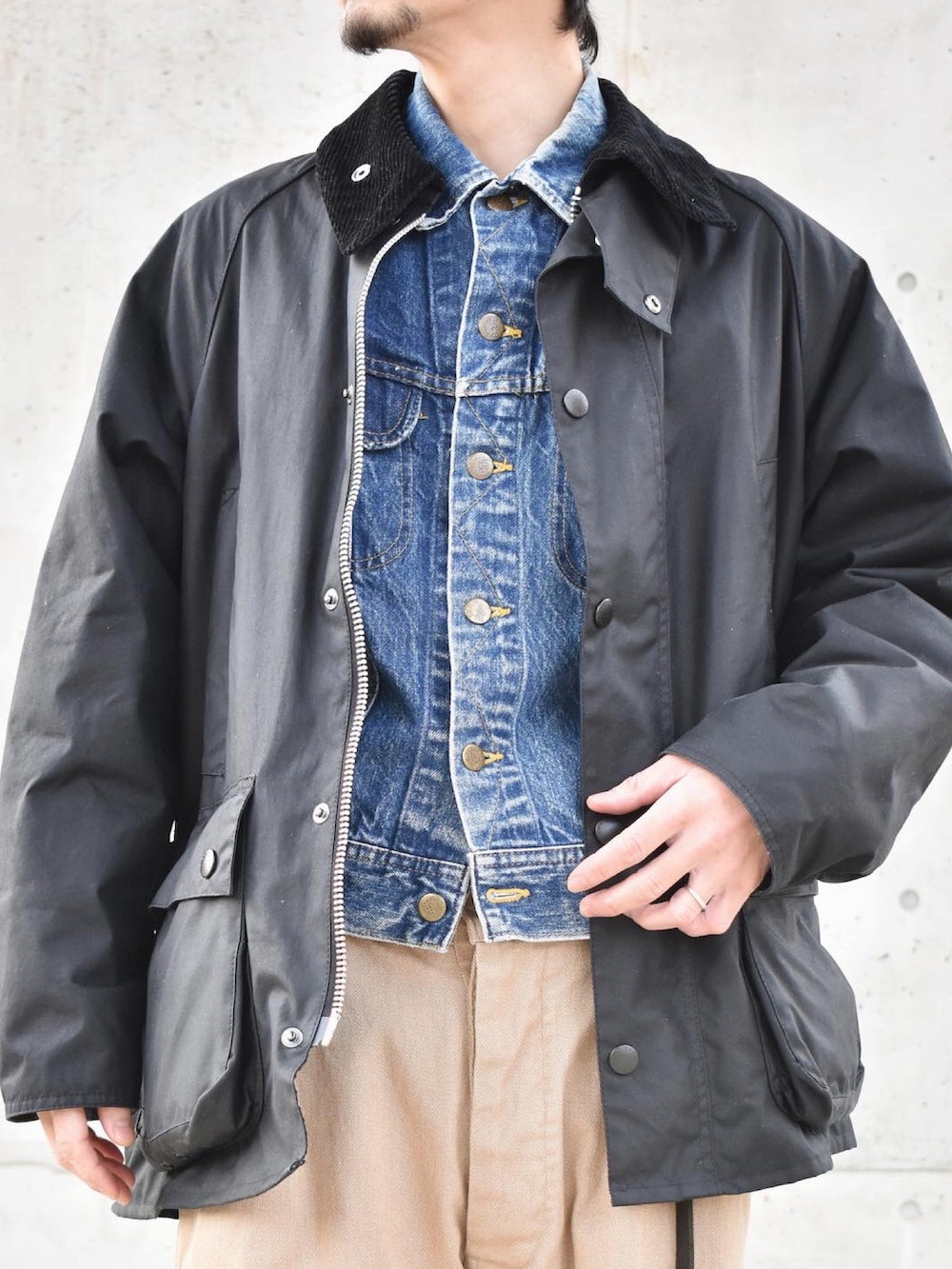 ブラック系のブルゾン、ブルー系のデニムジャケット、グリーン系のチノパンツを着用したメンズの冬コーディネートの2枚目の写真