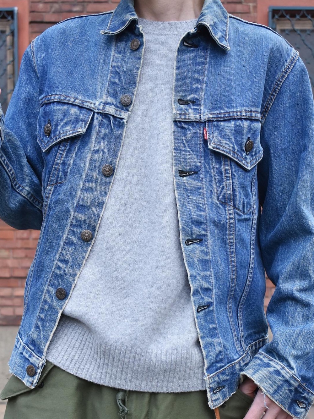 ブルー系のデニムジャケット、グリーン系のカーゴパンツ、グレー系のスニーカーを着用したメンズの冬コーディネートの2枚目の写真