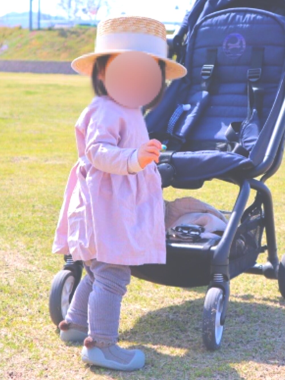 ピンク系のワンピース、グレー系のパンツ、グリーン系のシューズを着用したキッズの冬コーディネートの2枚目の写真