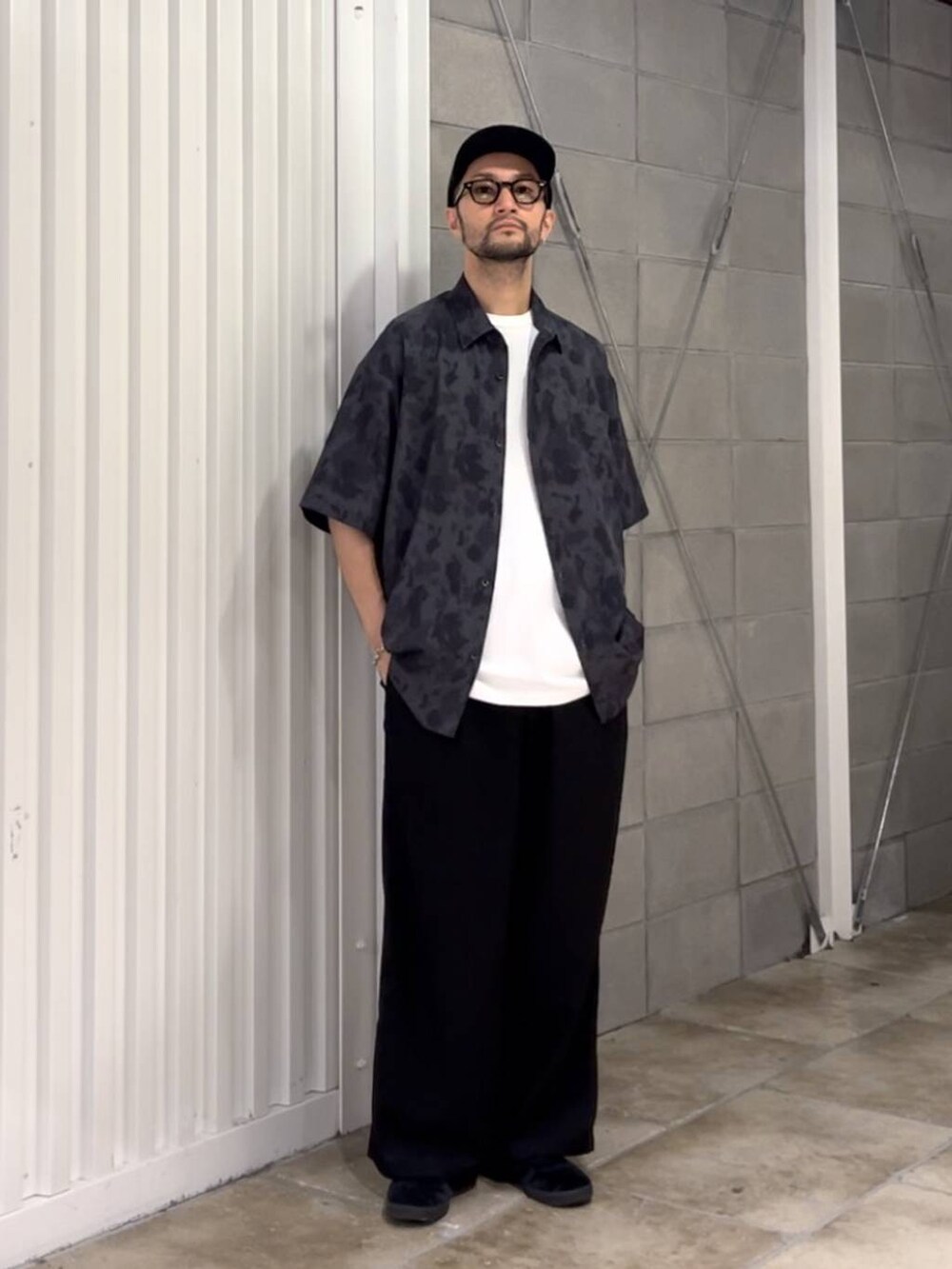 ブラック系のスラックス、ホワイト系のTシャツ/カットソー、ブラック系のシャツ/ブラウスを着用したメンズの夏コーディネートの5枚目の写真