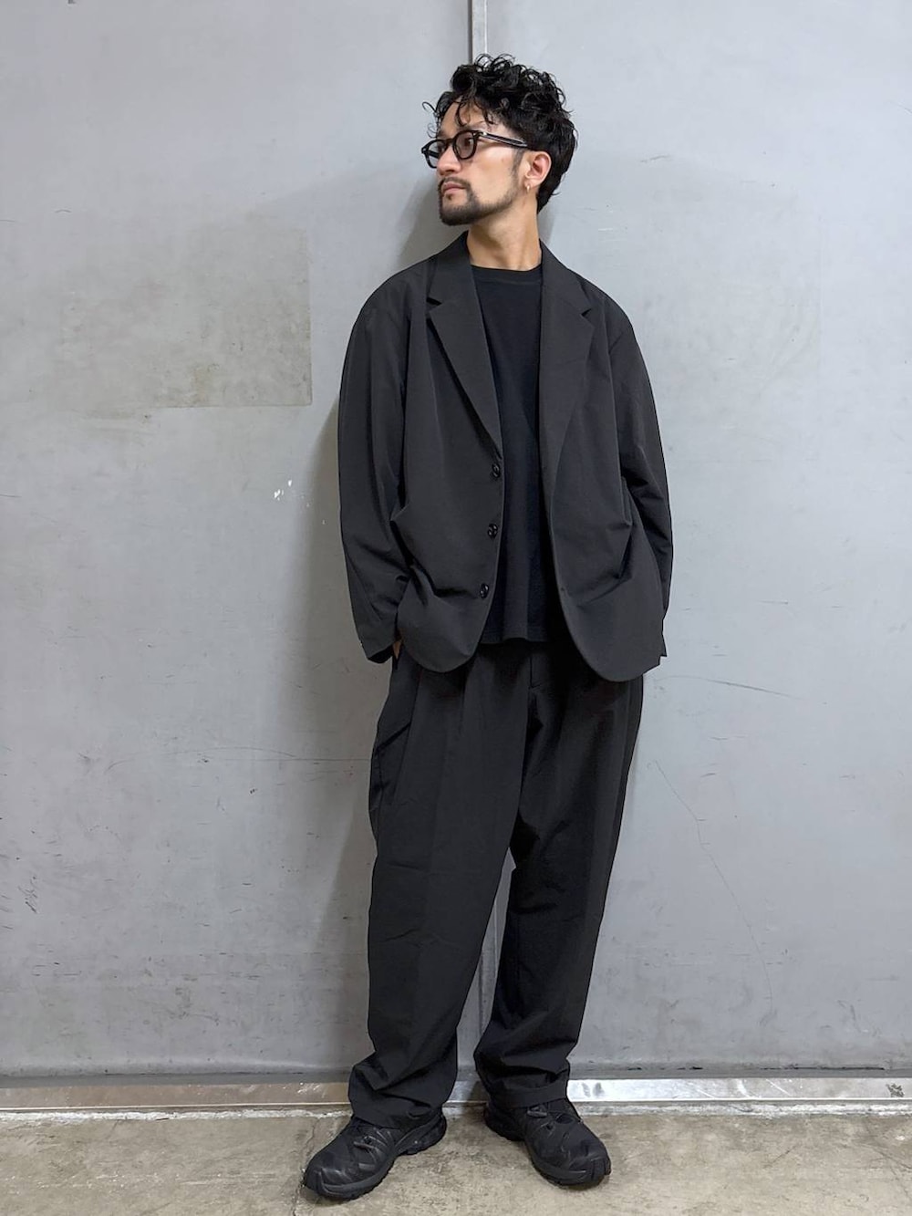 ブラック系のスニーカー、ブラック系のTシャツ/カットソー、ブラック系のスラックスを着用したメンズの夏コーディネートの4枚目の写真