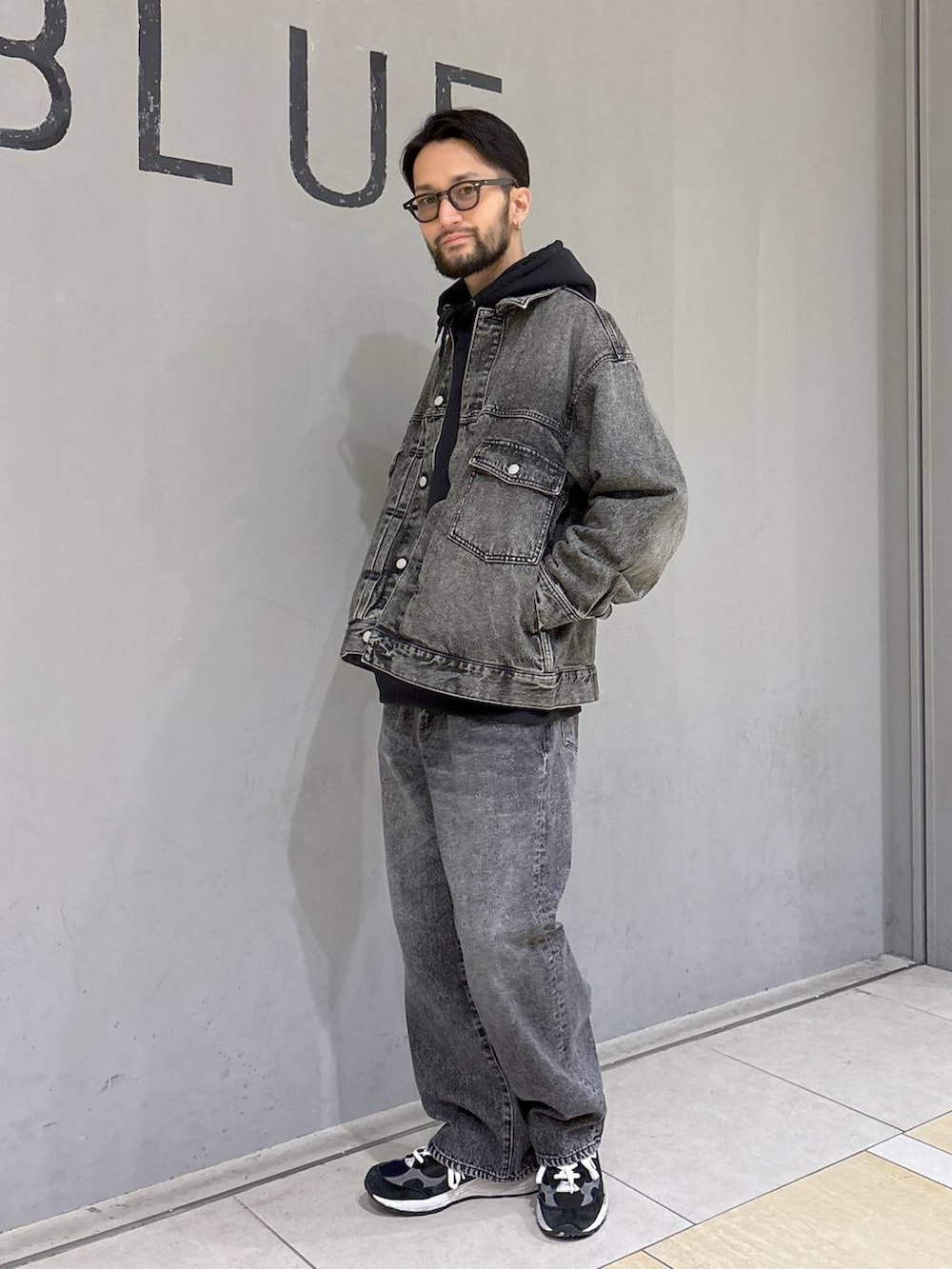 ブラック系のパーカー、グレー系のデニムジャケット、グレー系のデニムパンツを着用したメンズの冬コーディネートの2枚目の写真