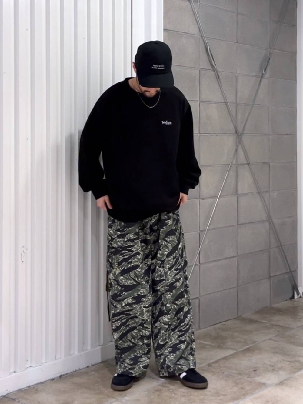 ブラック系のスニーカー、グリーン系のカーゴパンツ、ブラック系のスウェットを着用したメンズの秋コーディネートの3枚目の写真