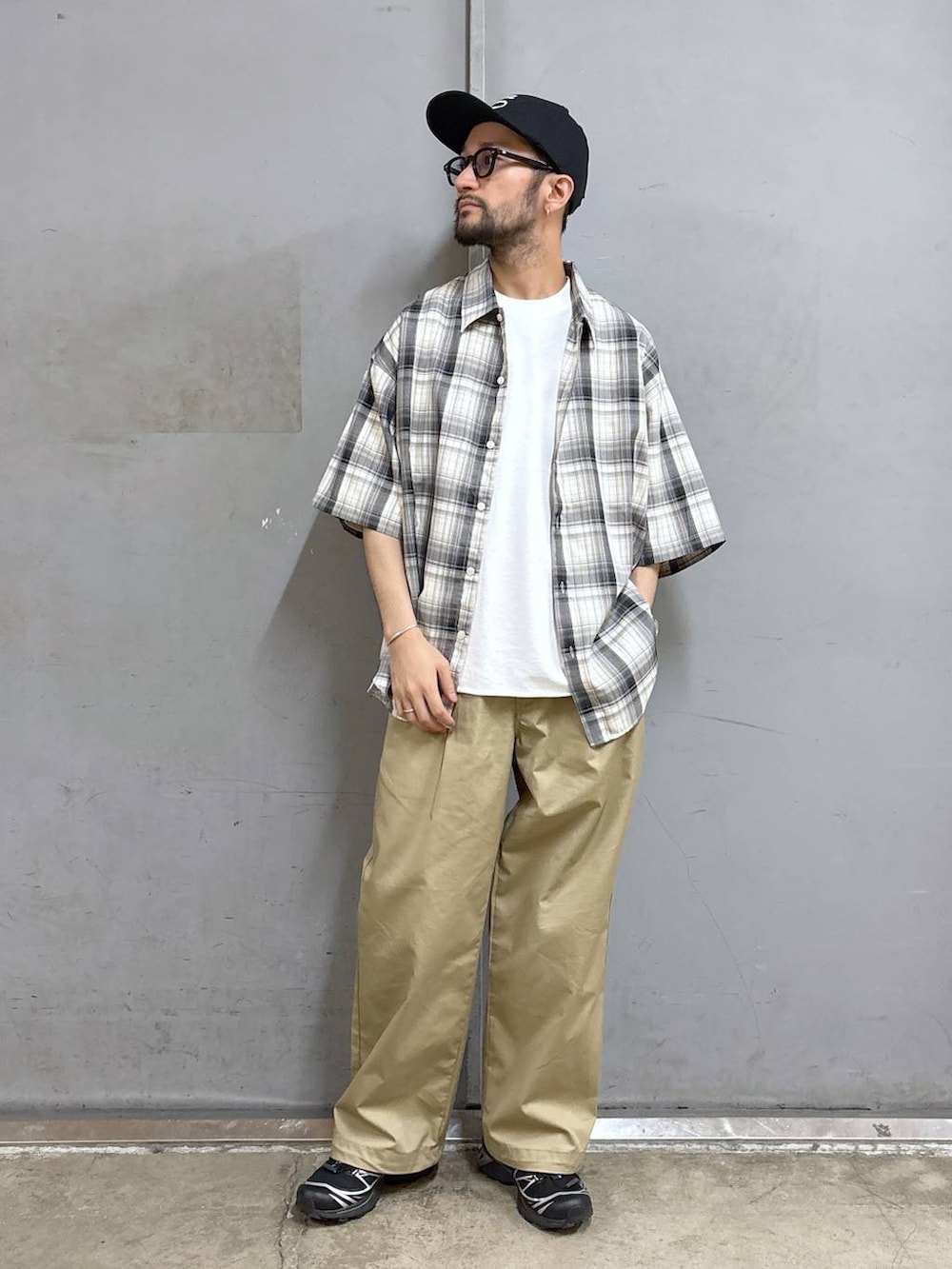 ベージュ系のチノパンツ、ホワイト系のTシャツ/カットソー、ブラック系のシャツ/ブラウスを着用したメンズの春コーディネートの2枚目の写真