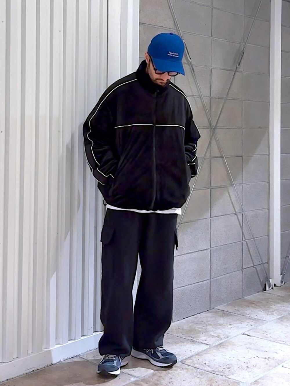 ブラック系のダウンジャケット/コート、ブラック系のスウェットパンツ、ブルー系のキャップを着用したメンズの冬コーディネートの4枚目の写真