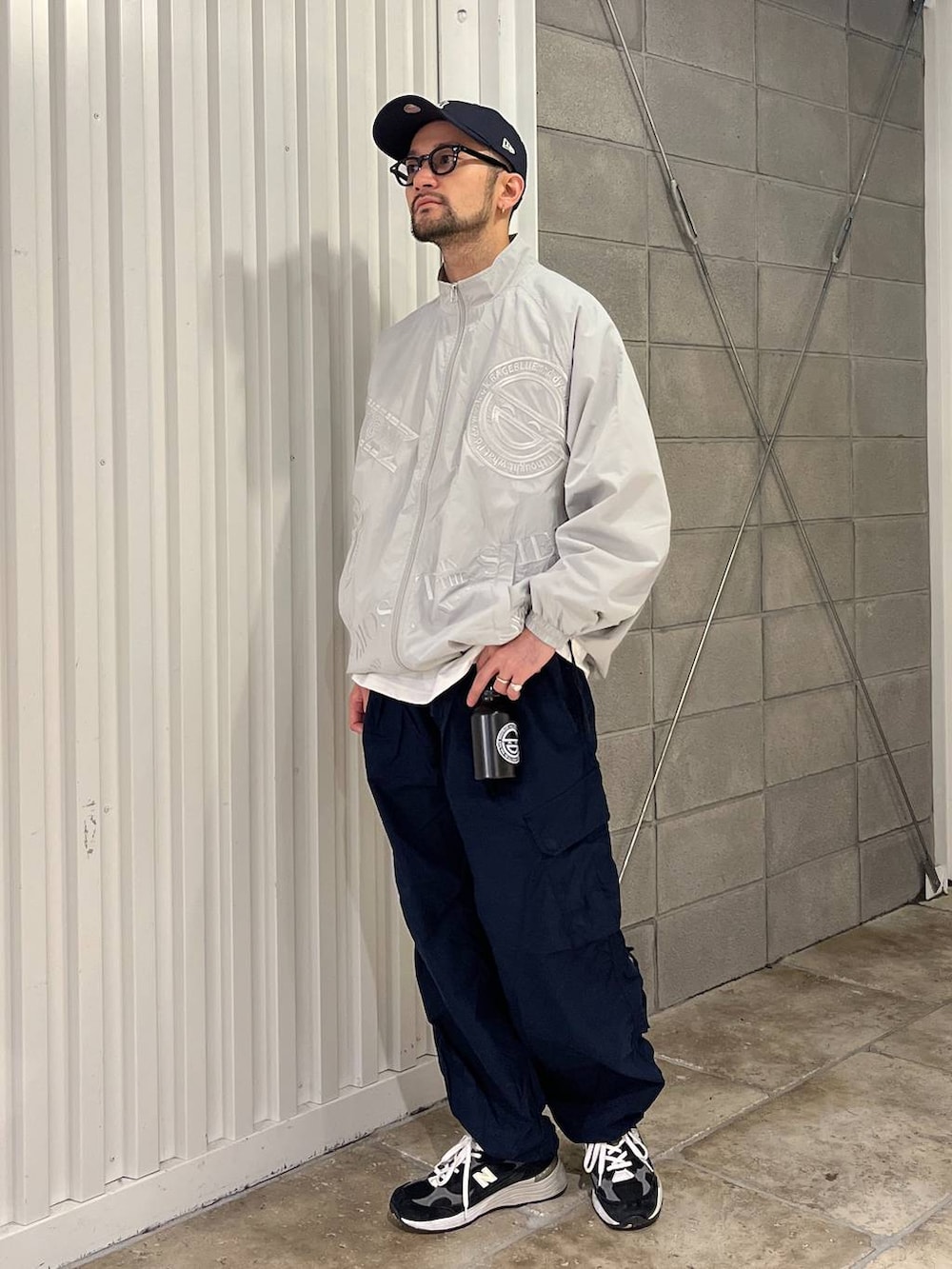 ホワイト系のTシャツ/カットソー、ブルー系のカーゴパンツ、グレー系のブルゾンを着用したメンズの春コーディネートの2枚目の写真