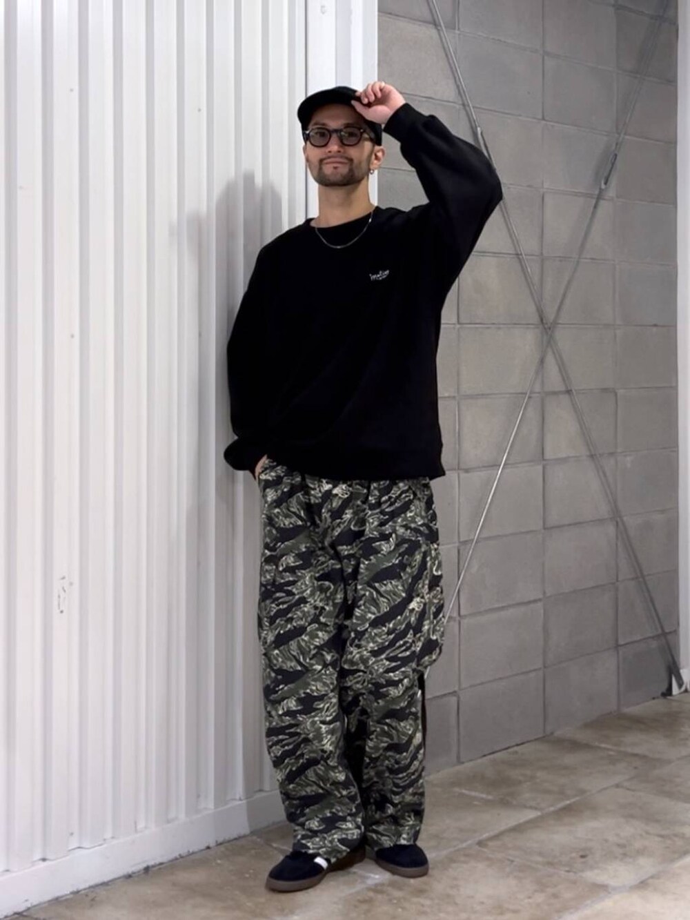 ブラック系のスニーカー、グリーン系のカーゴパンツ、ブラック系のスウェットを着用したメンズの秋コーディネートの4枚目の写真