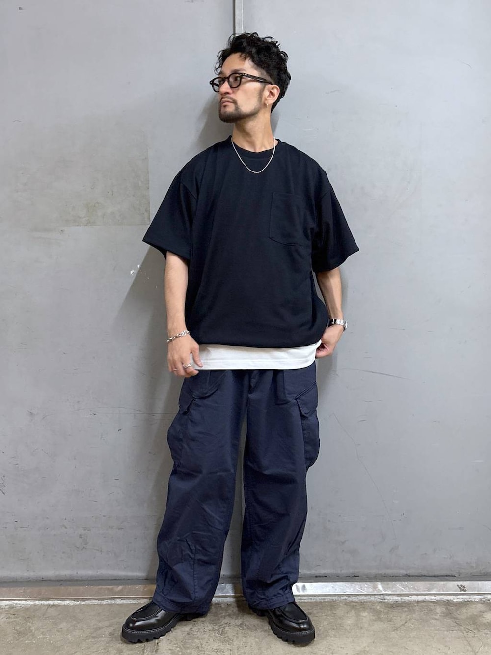 ブラック系のドレスシューズ、ホワイト系のタンクトップ、ブルー系のカーゴパンツを着用したメンズの夏コーディネートの2枚目の写真