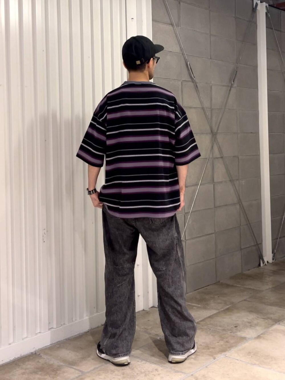 ブラック系のTシャツ/カットソー、グレー系のデニムパンツを着用したメンズの夏コーディネートの4枚目の写真