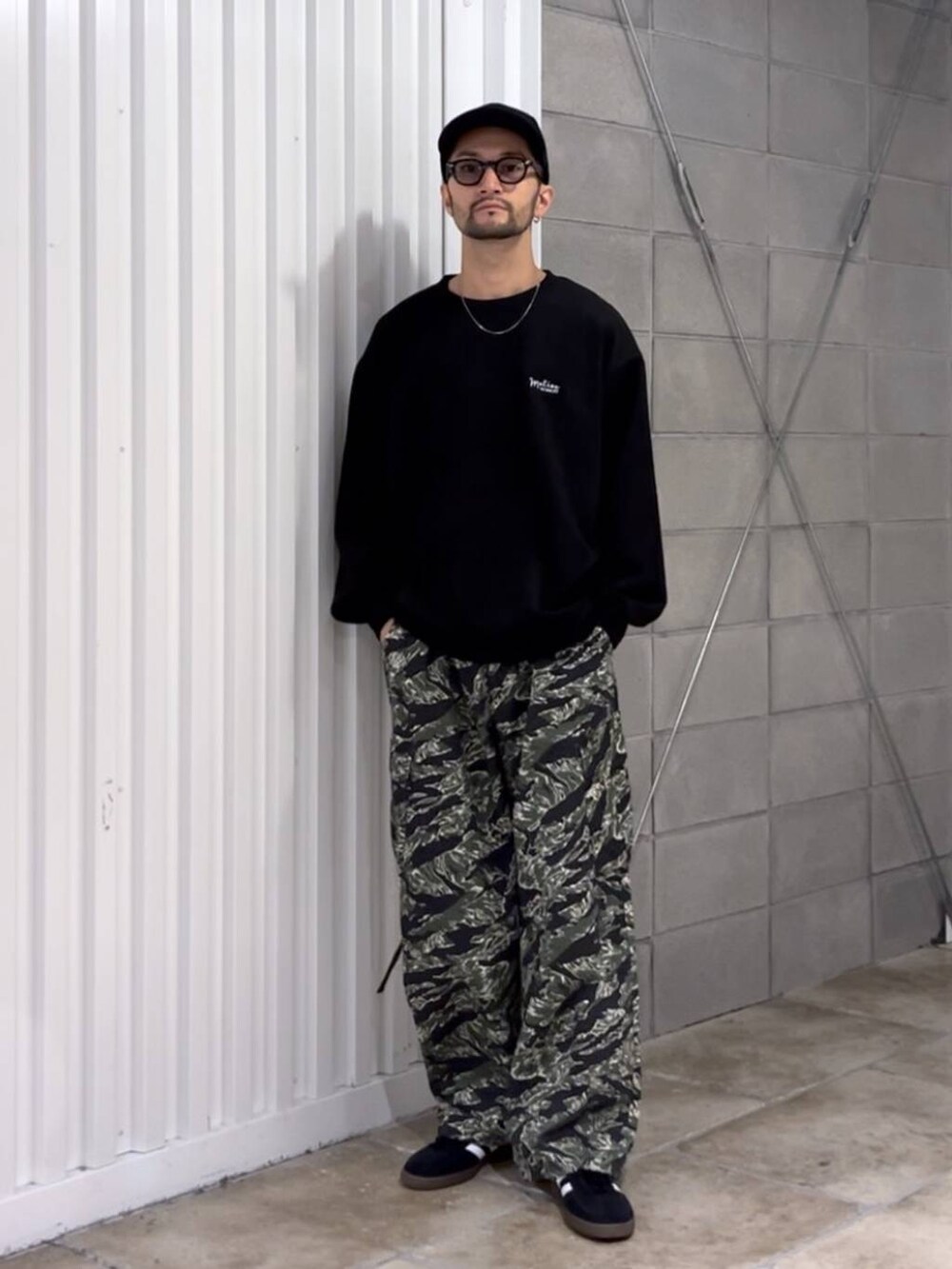 ブラック系のスニーカー、グリーン系のカーゴパンツ、ブラック系のスウェットを着用したメンズの秋コーディネートの5枚目の写真