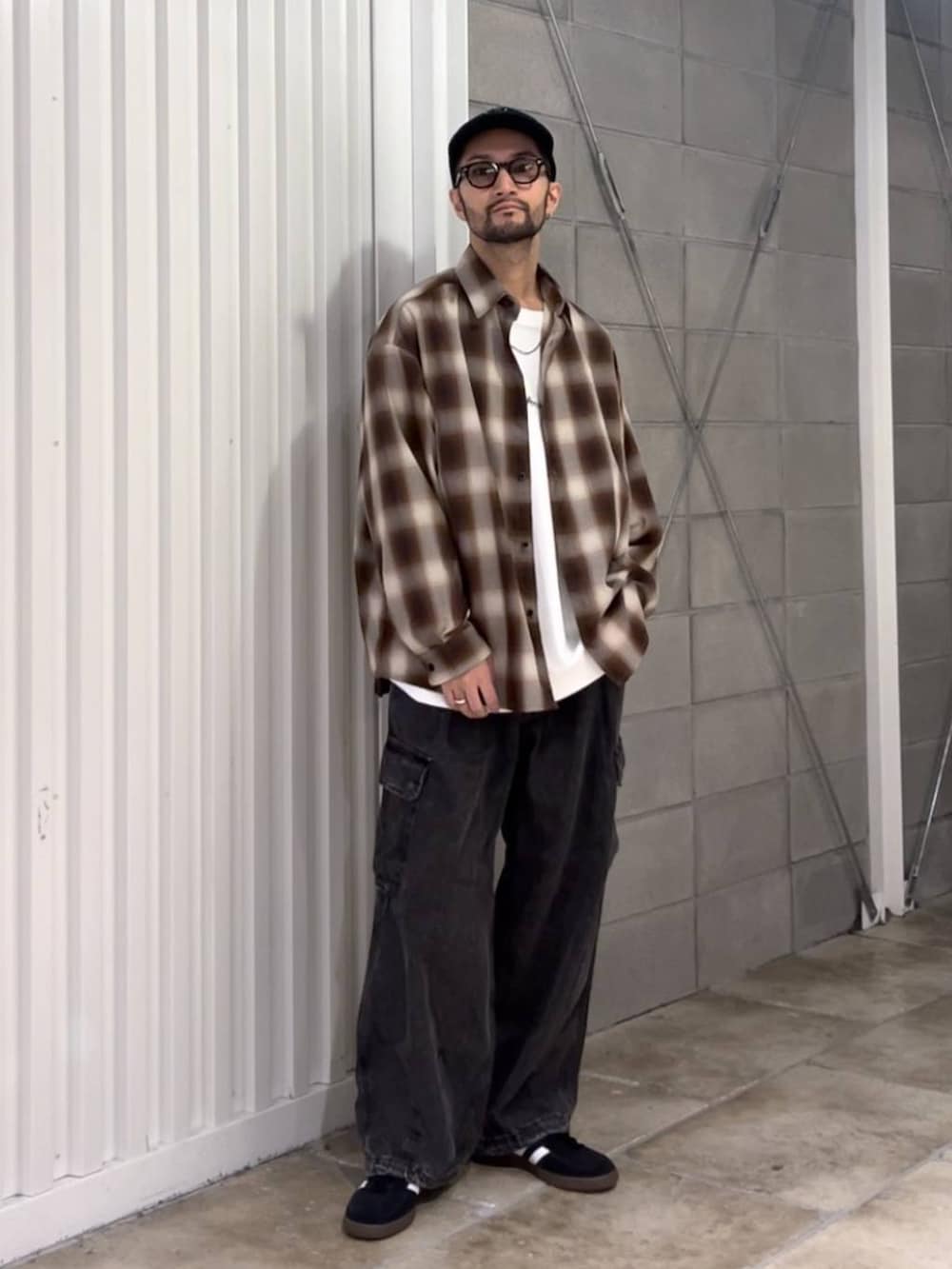 ブラック系のスニーカー、グレー系のデニムパンツ、ホワイト系のTシャツ/カットソーを着用したメンズの秋コーディネートの5枚目の写真