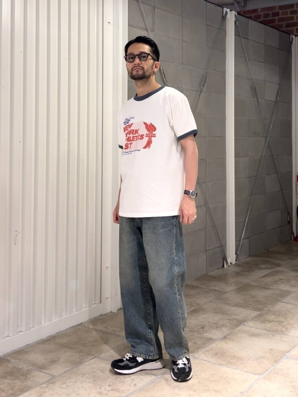 ブルー系のデニムパンツ、ホワイト系のTシャツ/カットソー、ブラック系のベルトを着用したメンズの夏コーディネートの2枚目の写真