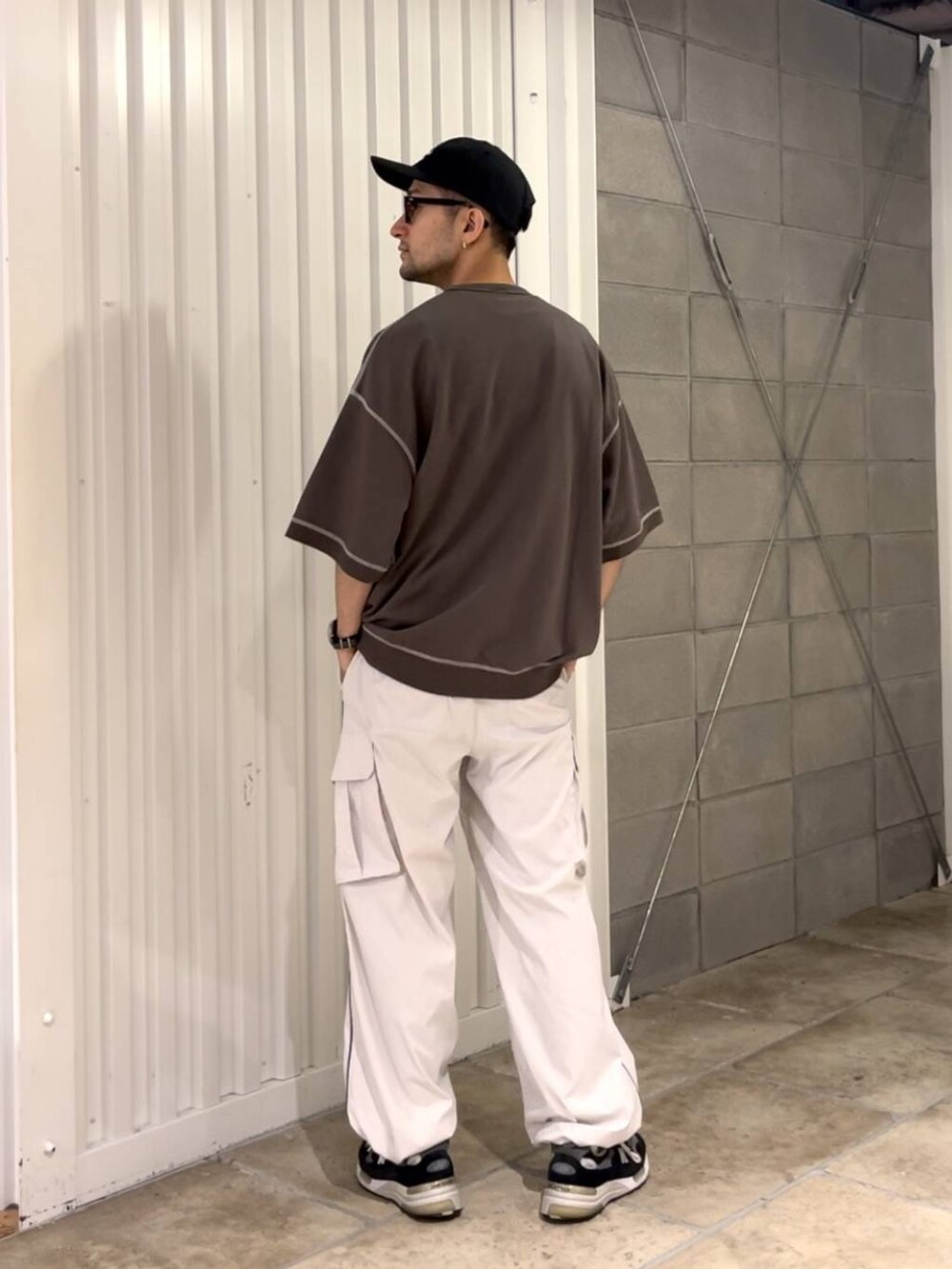 ブラック系のTシャツ/カットソー、ホワイト系のカーゴパンツを着用したメンズの夏コーディネートの4枚目の写真