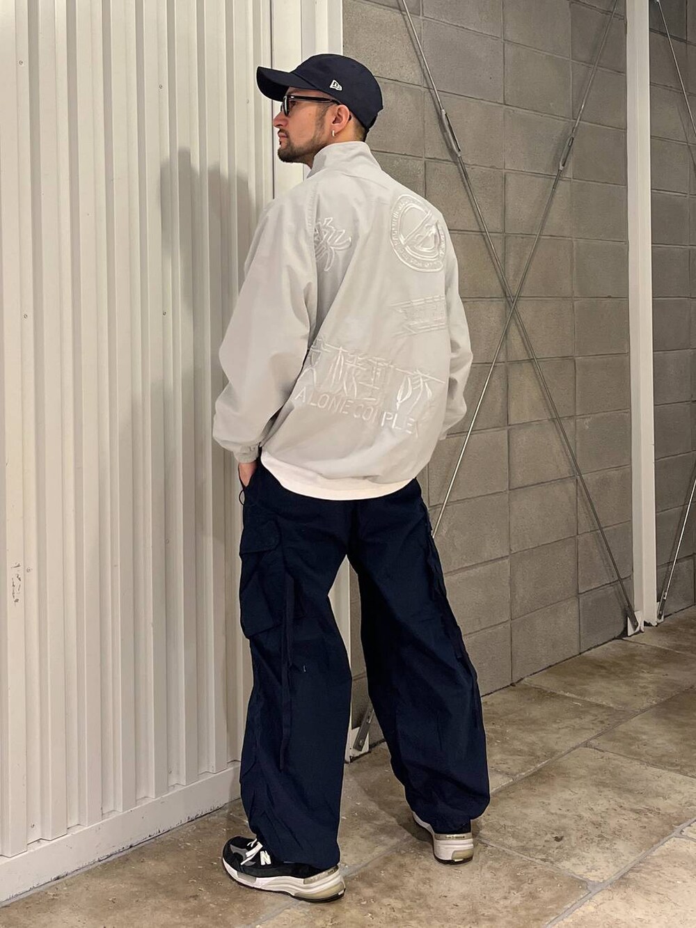 ホワイト系のTシャツ/カットソー、ブルー系のカーゴパンツ、グレー系のブルゾンを着用したメンズの春コーディネートの3枚目の写真