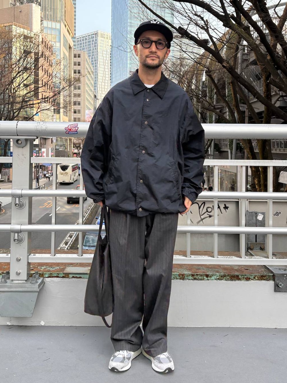 グレー系のスラックス、ホワイト系のTシャツ/カットソーを着用したメンズの春コーディネートの3枚目の写真