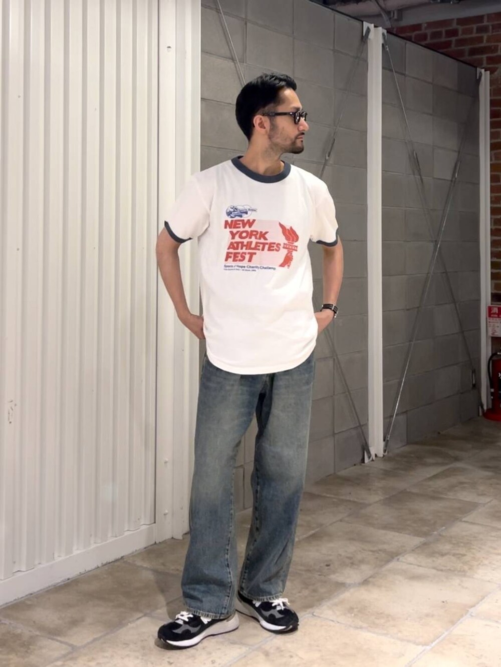 ブルー系のデニムパンツ、ホワイト系のTシャツ/カットソー、ブラック系のベルトを着用したメンズの夏コーディネートの4枚目の写真