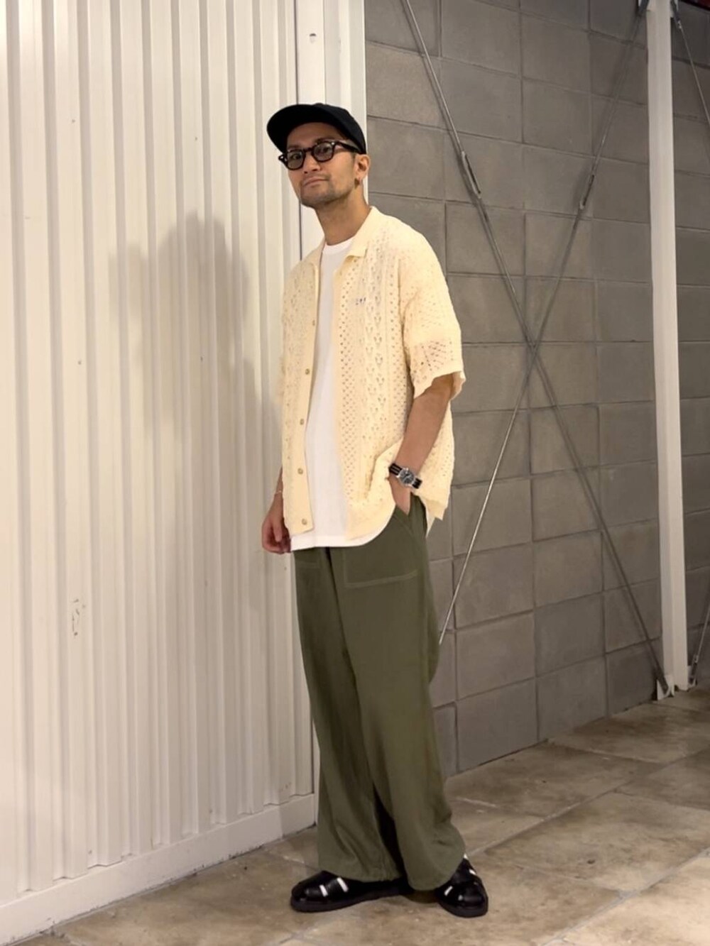 ブラック系のサンダル、ホワイト系のシャツ/ブラウス、グリーン系のスラックスを着用したメンズの夏コーディネートの3枚目の写真