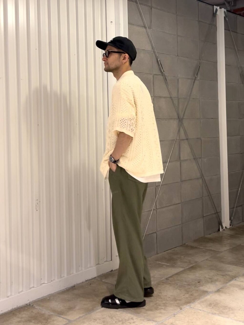 ブラック系のサンダル、ホワイト系のシャツ/ブラウス、グリーン系のスラックスを着用したメンズの夏コーディネートの4枚目の写真