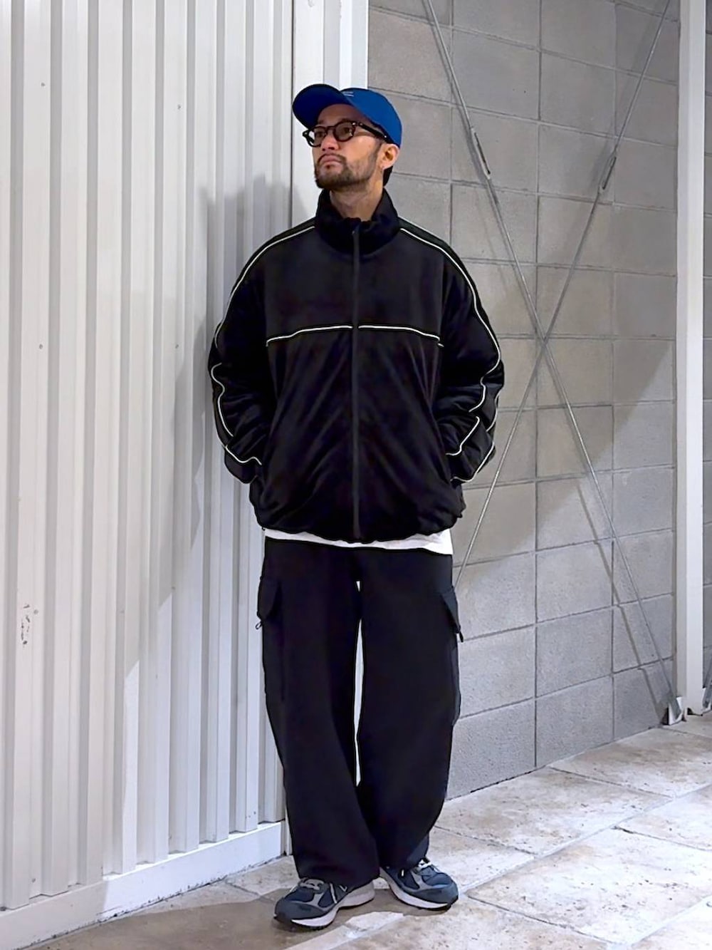 ブラック系のダウンジャケット/コート、ブラック系のスウェットパンツ、ブルー系のキャップを着用したメンズの冬コーディネートの5枚目の写真