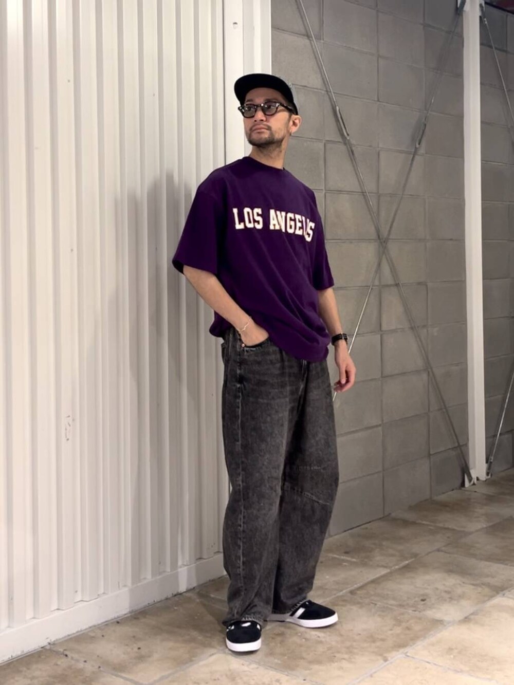 パープル系のTシャツ/カットソー、グレー系のデニムパンツ、ブラック系のスニーカーを着用したメンズの夏コーディネートの2枚目の写真