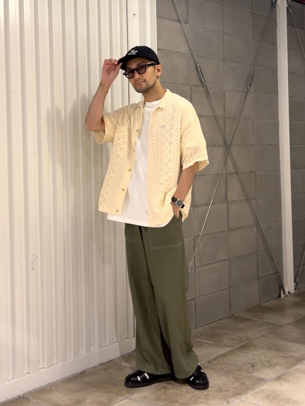 ブラック系のサンダル、ホワイト系のシャツ/ブラウス、グリーン系のスラックスを着用したメンズの夏コーディネートの2枚目の写真