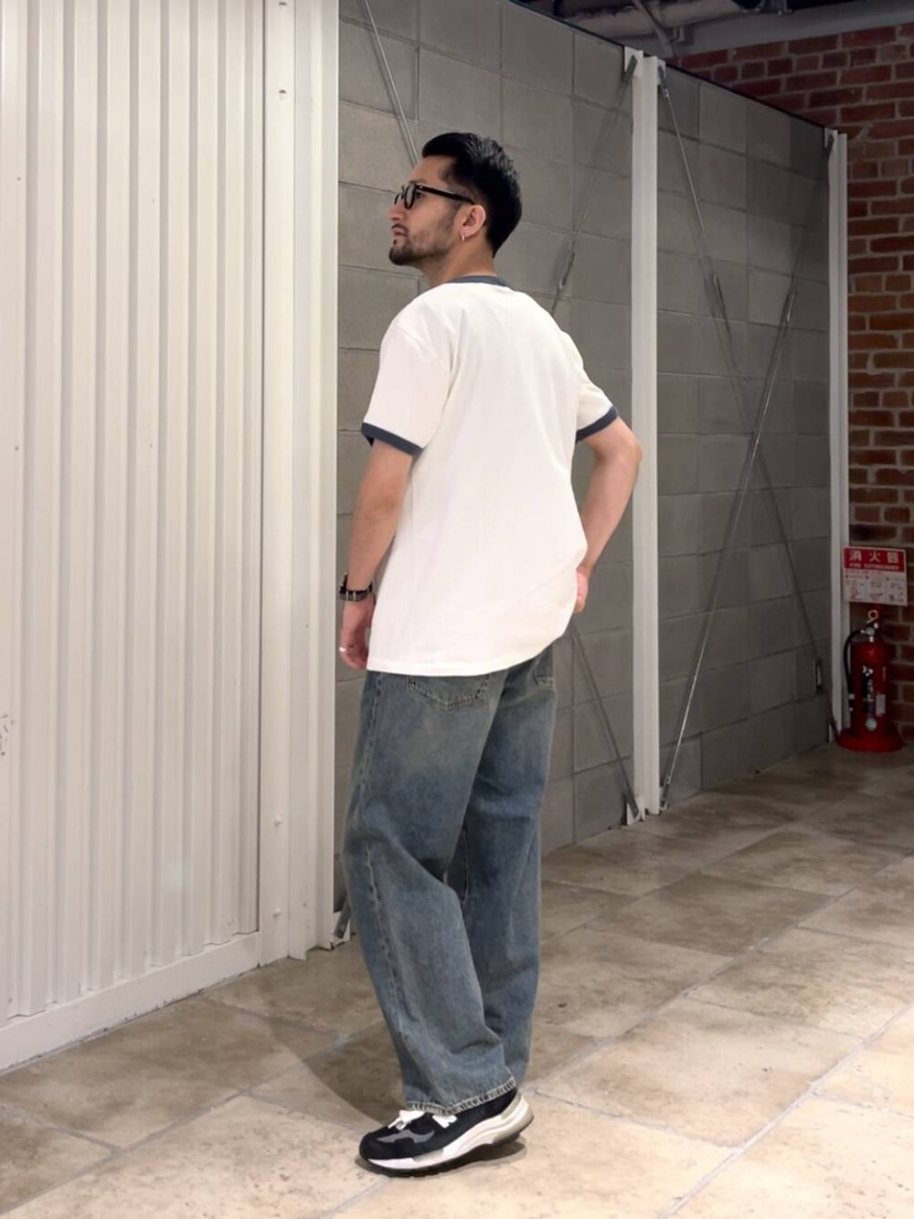 ブルー系のデニムパンツ、ホワイト系のTシャツ/カットソー、ブラック系のベルトを着用したメンズの夏コーディネートの5枚目の写真