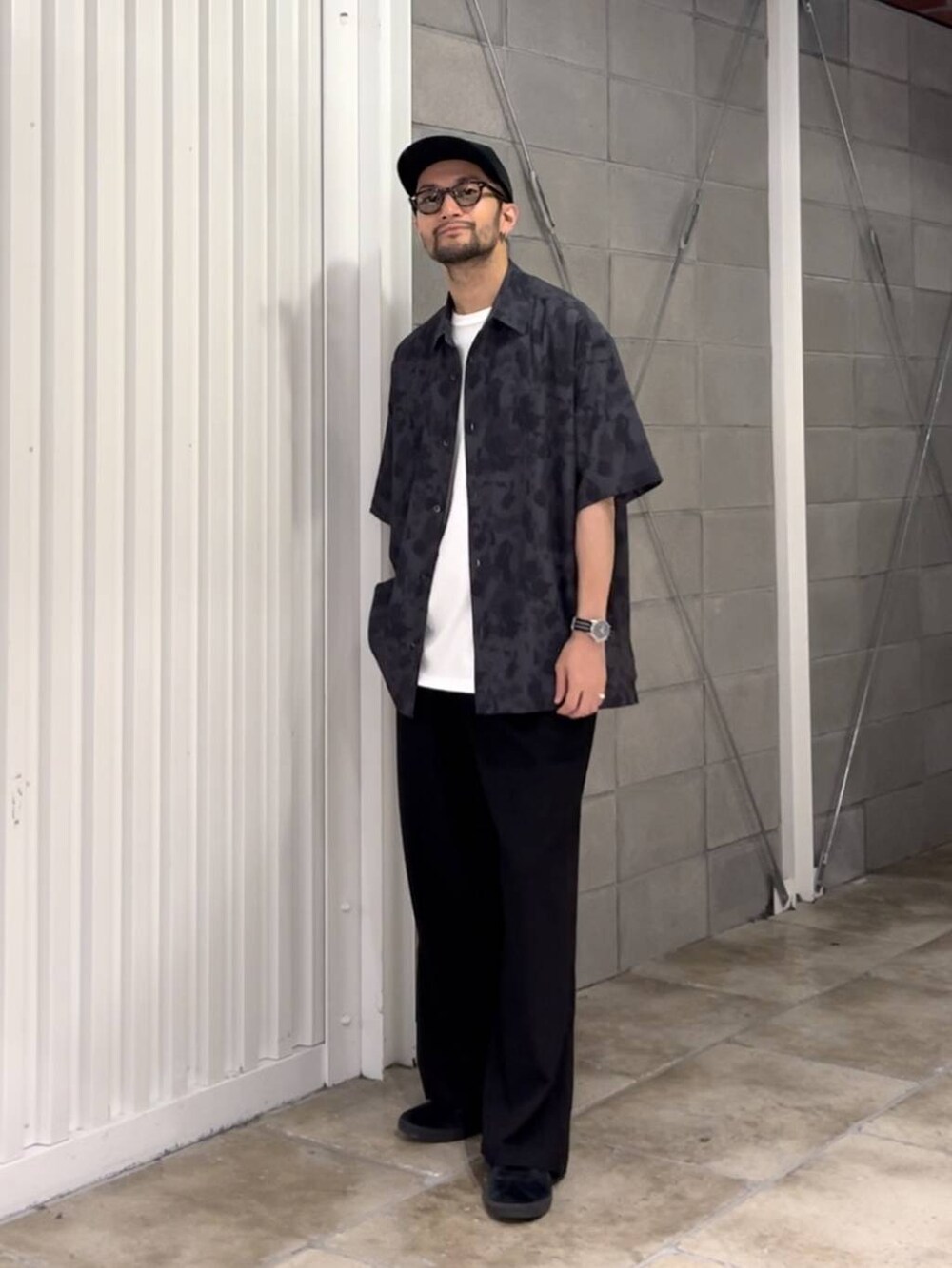 ブラック系のスラックス、ホワイト系のTシャツ/カットソー、ブラック系のシャツ/ブラウスを着用したメンズの夏コーディネートの2枚目の写真