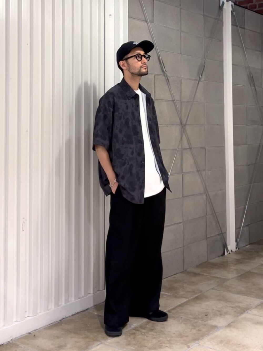 ブラック系のスラックス、ホワイト系のTシャツ/カットソー、ブラック系のシャツ/ブラウスを着用したメンズの夏コーディネートの3枚目の写真