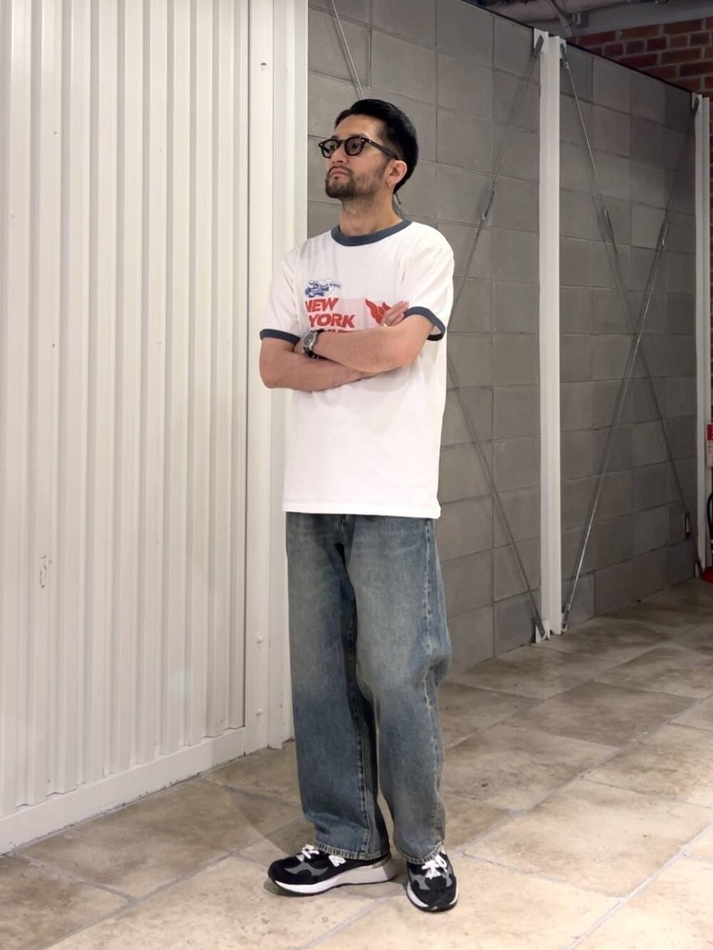 ブルー系のデニムパンツ、ホワイト系のTシャツ/カットソー、ブラック系のベルトを着用したメンズの夏コーディネートの3枚目の写真