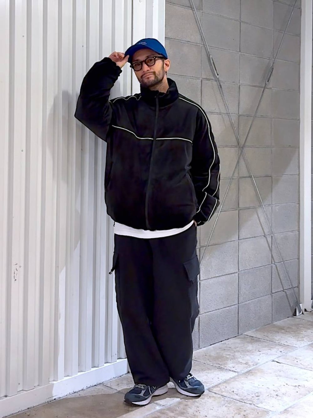 ブラック系のダウンジャケット/コート、ブラック系のスウェットパンツ、ブルー系のキャップを着用したメンズの冬コーディネートの3枚目の写真