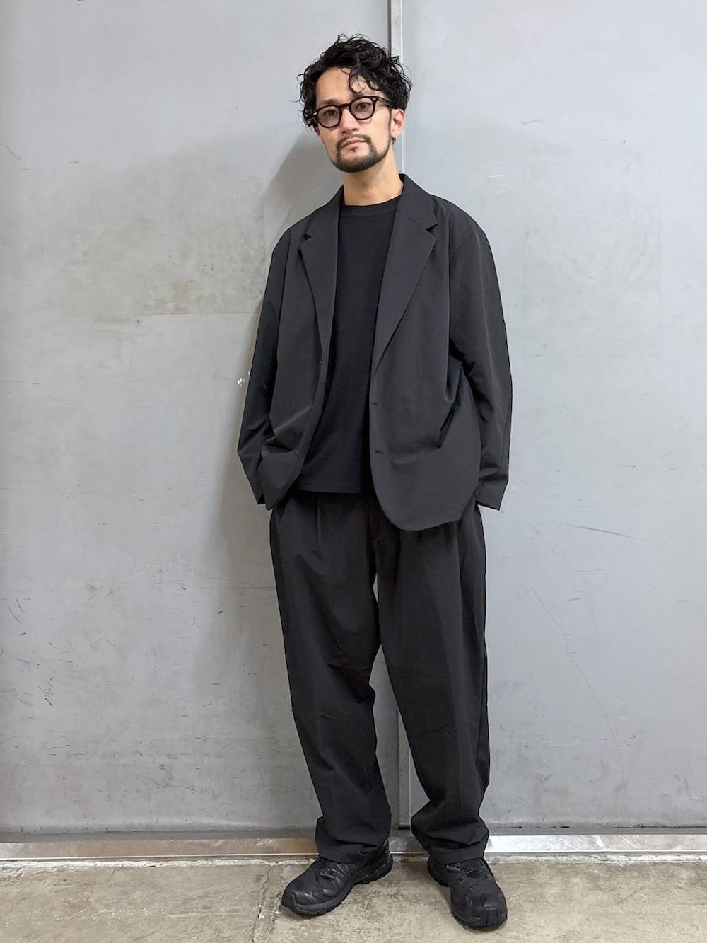 ブラック系のスニーカー、ブラック系のTシャツ/カットソー、ブラック系のスラックスを着用したメンズの夏コーディネートの5枚目の写真