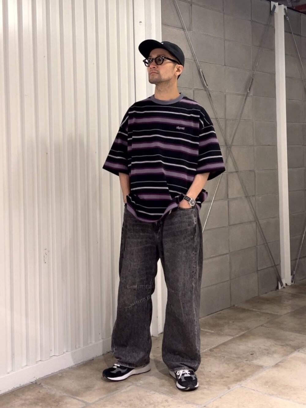 ブラック系のTシャツ/カットソー、グレー系のデニムパンツを着用したメンズの夏コーディネートの5枚目の写真