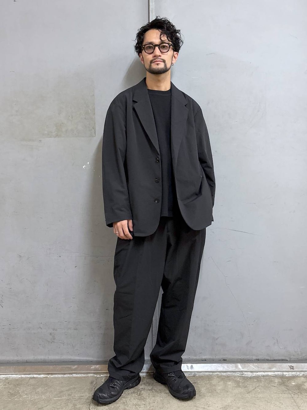 ブラック系のスニーカー、ブラック系のTシャツ/カットソー、ブラック系のスラックスを着用したメンズの夏コーディネートの3枚目の写真