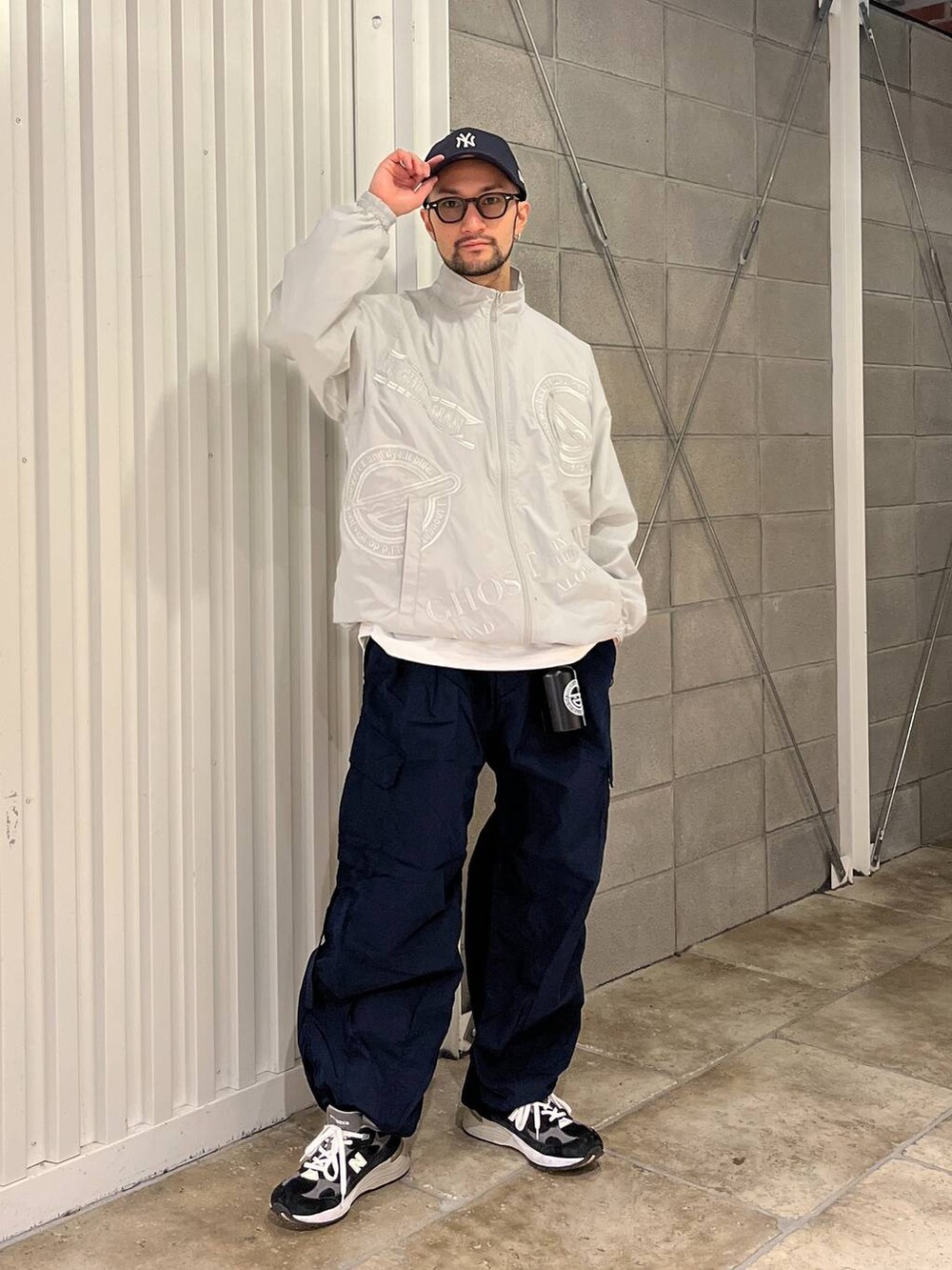 ホワイト系のTシャツ/カットソー、ブルー系のカーゴパンツ、グレー系のブルゾンを着用したメンズの春コーディネートの4枚目の写真